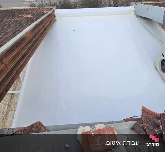 גג אטום עם חומר לבן, רעפים שבורים בצד